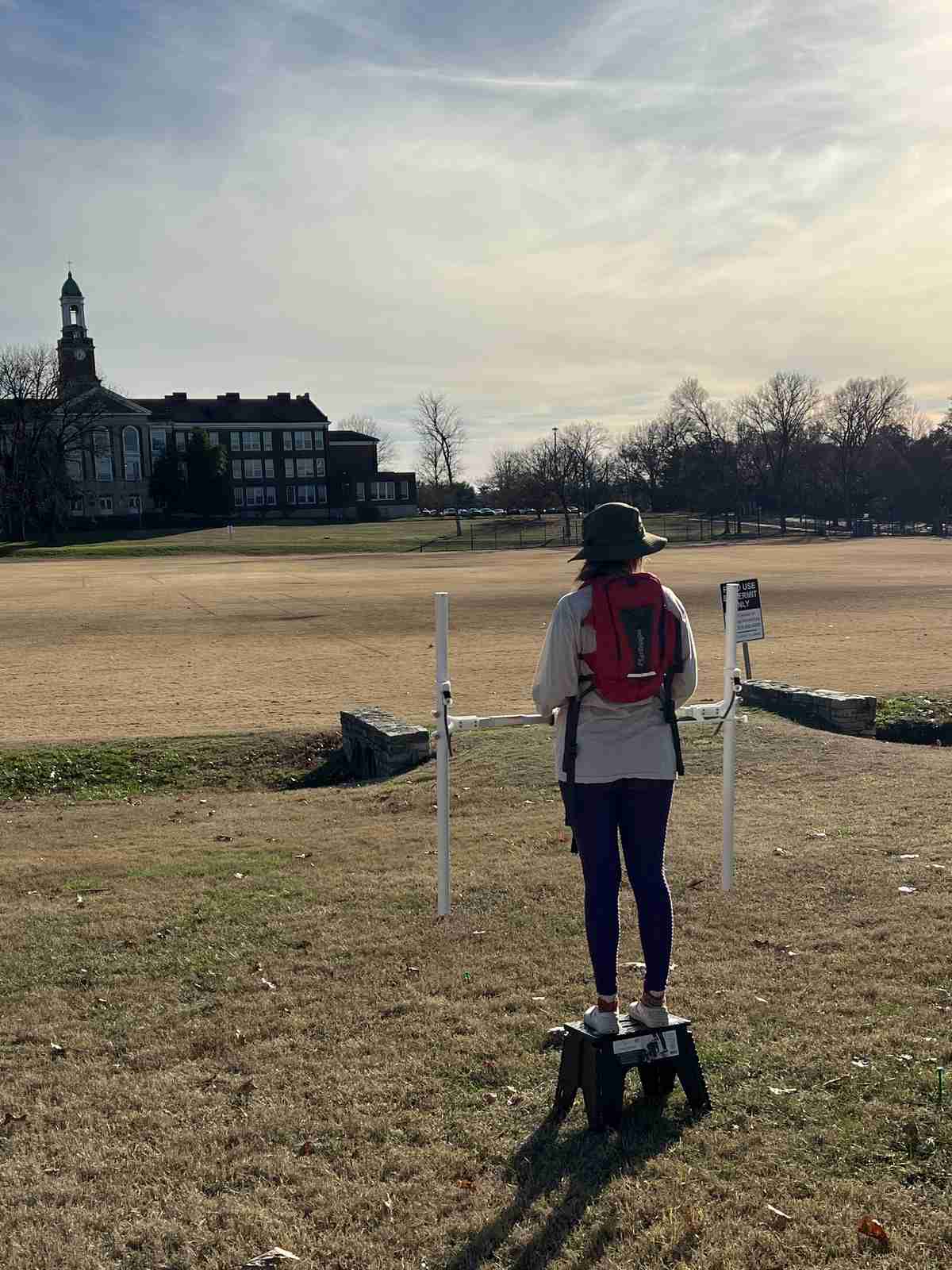 A VISR researcher carrying the Bartington Grad601 Fluxgate Magnetic Gradiometer frame across a survey field