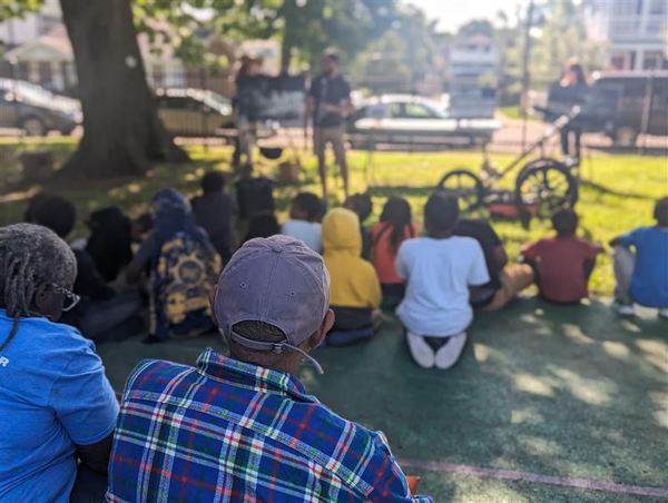 Community members gathered outdoors near VISR survey equipment at an engagement event